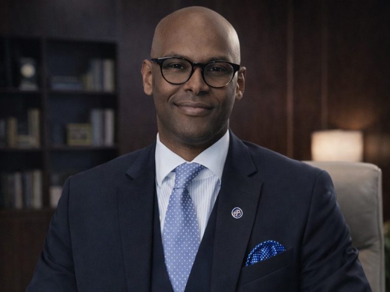 Gregor Ghirmay steht neben dem Büro Tischkickertisch und vor den Fußballtrikots von Mpappe, Neymar und Eintracht Frankfurt